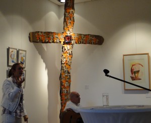 Anja Guntrum erläutert "Vielschichtig V" von Claudia Hüfner, mit dem Titel "Persönliches Paradies", Kreuz aus Pappschachteln, 200 Origami-Kreuze, Papier handgeschöpft (Herz und Adern), 350 cm x 165 cm, 2012